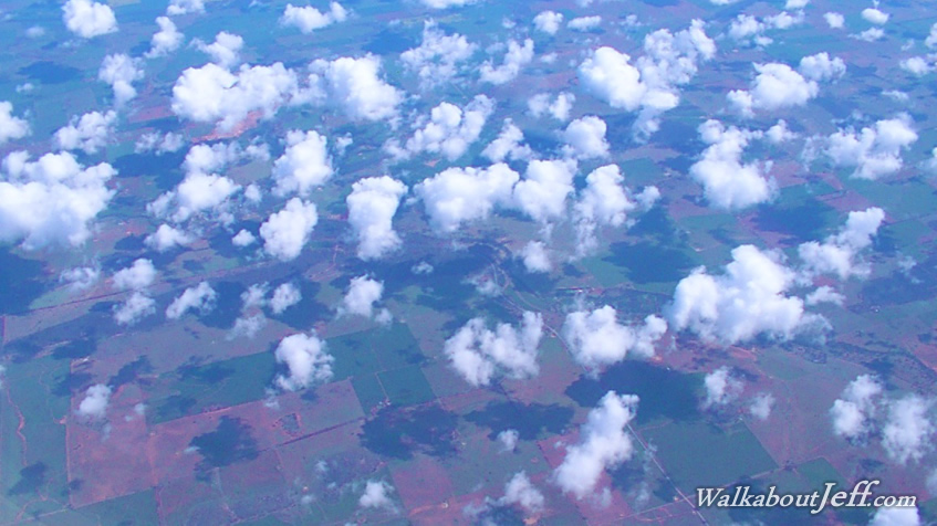 Puffy clouds over farmland